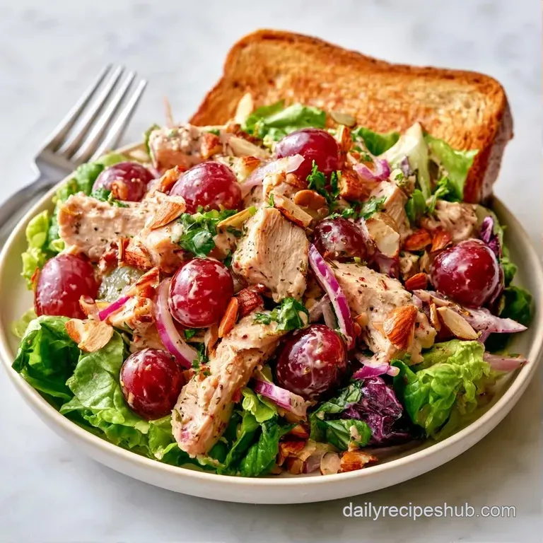 A chilled scoop of creamy chicken salad on crisp lettuce leaves with sliced cucumbers and toasted multigrain bread.